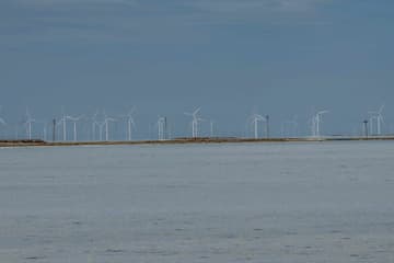 海面上排列着许多风力发电机组 天空晴朗