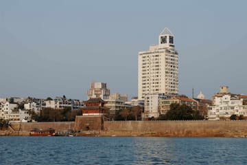 城市建筑群沿水岸线分布 高楼与传统建筑并存 天空晴朗