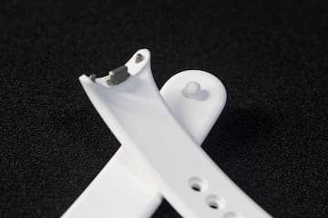 白色硅胶表带交叉放置于黑色背景上细节展示表带的纹理和连接部件