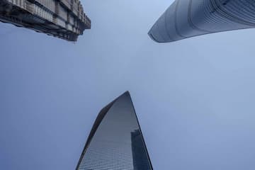 从低角度拍摄的三座摩天大楼建筑 蓝天作为背景 建筑风格各异