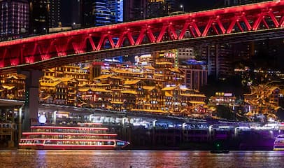 夜幕下红桥横跨江面 岸边建筑灯火辉煌 江面游船行驶
