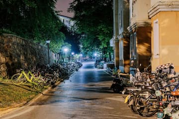 夜晚的道路两旁停满了自行车 远处有灯光照亮 建筑和树木环绕