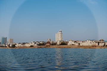 城市建筑群临水而立晴朗天空背景
