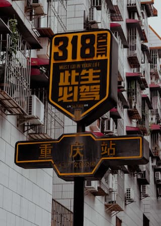 路牌显示318和重庆站字样建筑背景空调外机密集