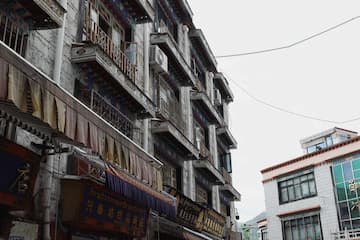 拍摄了具有藏式风格的建筑群，建筑外立面老旧，阳台突出。