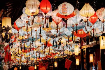 图片展示了许多不同颜色和款式的灯笼悬挂在空中。