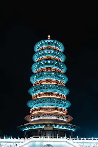 夜间拍摄的宝塔，被蓝色和橙色灯光照亮。