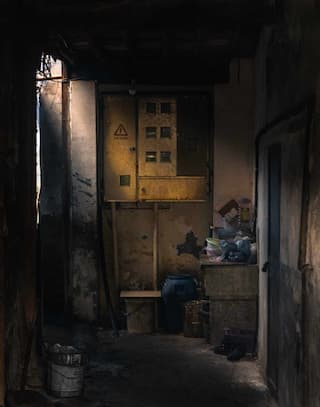 小巷深处堆满杂物 电箱醒目 整体光线昏暗 营造出一种压抑的氛围