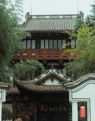 图片展示了一座具有中国传统风格的建筑 飞檐翘角 掩映在绿树之中