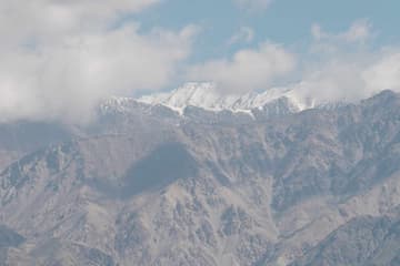 山脉被云雾环绕 山顶覆盖着白雪 景色壮丽