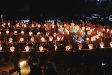 夜晚人群举着灯笼在移动 队伍庞大灯光闪烁