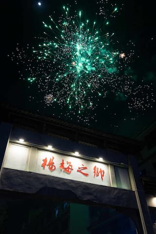 夜空中绽放着绿色烟花牌坊上写着“梧桐之御”字样