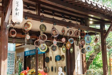 店铺屋檐下悬挂着各种手工编织品，室内展示着商品。