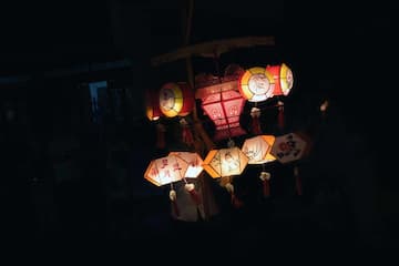 图片展示了夜晚中悬挂的各种形状和颜色的灯笼。