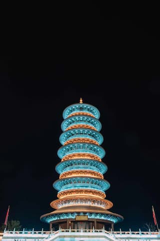 图片展示了一座在夜间被灯光照亮的宝塔，塔身结构独特，层次分明。