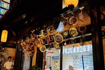 图片展示了室内悬挂的金属装饰品，同时有灯笼和演奏者在场。
