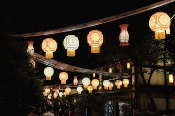 夜晚拍摄的灯笼装饰场景，多个灯笼悬挂在空中，照亮周围环境。
