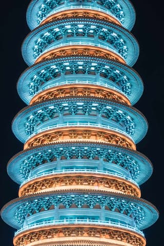 图片展示了一座多层宝塔建筑，夜间灯光照亮，结构复杂。