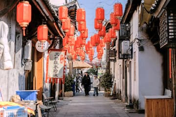 街道两旁挂满红灯笼 游客在街道上行走 古色古香的建筑风格