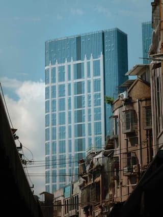 图片展示了现代玻璃幕墙高楼与老旧建筑并存的城市景观新旧对比强烈