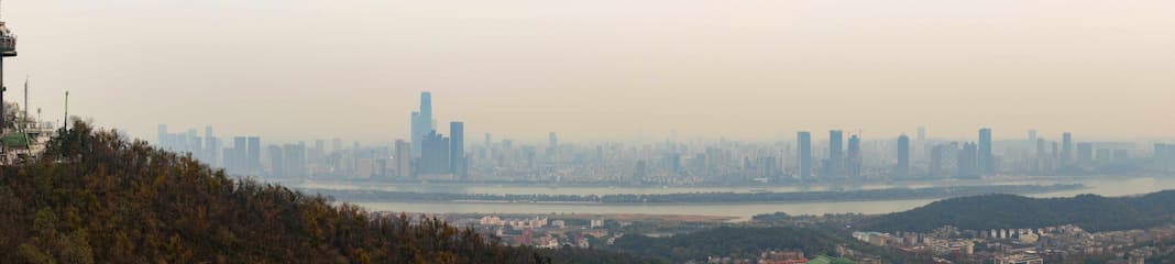 城市景观被雾霾笼罩远处的摩天大楼若隐若现近处山丘植被覆盖