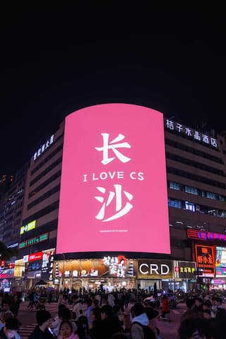 夜晚城市街道人流涌动 粉色广告牌醒目写着I LOVE CS