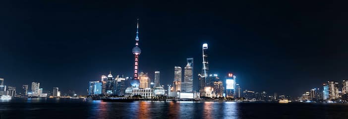 图片展示了上海的夜景，城市天际线被灯光点亮，东方明珠塔非常醒目