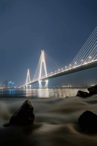 夜晚的桥梁在灯光照耀下显得格外壮观水面上的波光与桥梁的倒影相互辉映