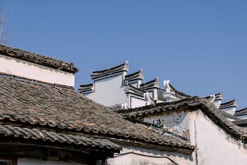 灰瓦白墙的徽派建筑屋顶在蓝天下呈现出独特的韵味和历史感