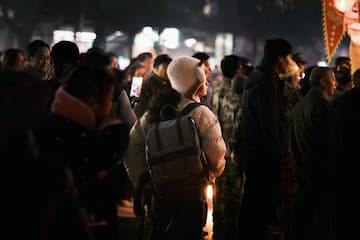 夜晚人群聚集有人背着背包有人拿着手机拍摄气氛热闹