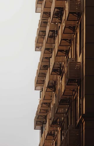 建筑外墙上安装了多个消防逃生梯 结构重复排列 呈现出独特的建筑外观