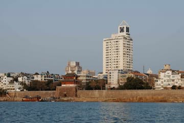 城市建筑群沿水岸线分布 高楼与传统建筑并存 天空晴朗