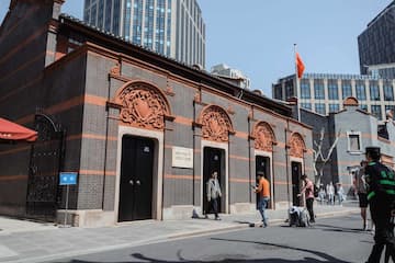 砖红色建筑立面装饰精美人物活动于建筑前街道上空飘扬着红旗