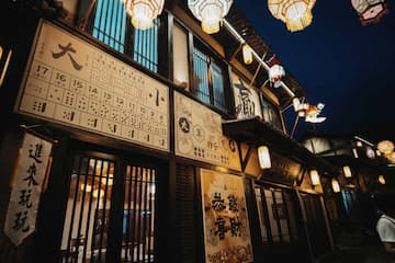 夜色中古镇的街景，挂着灯笼，建筑风格古朴。