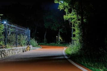 夜晚的公园跑道空无一人路灯照亮前方的路自行车停靠在路边