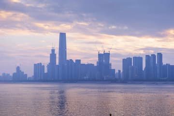 城市建筑群在水面上形成倒影天空呈现出柔和的色彩