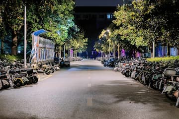 夜晚的道路两旁停满了自行车 树木在灯光下显得生机勃勃
