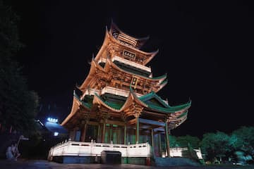 夜间拍摄的中国传统多层楼阁建筑，灯光照亮建筑结构。