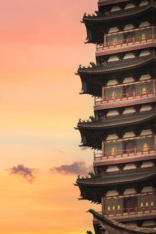 图片展示了一座多层宝塔建筑 沐浴在夕阳的余晖中 天空呈现出渐变的色彩